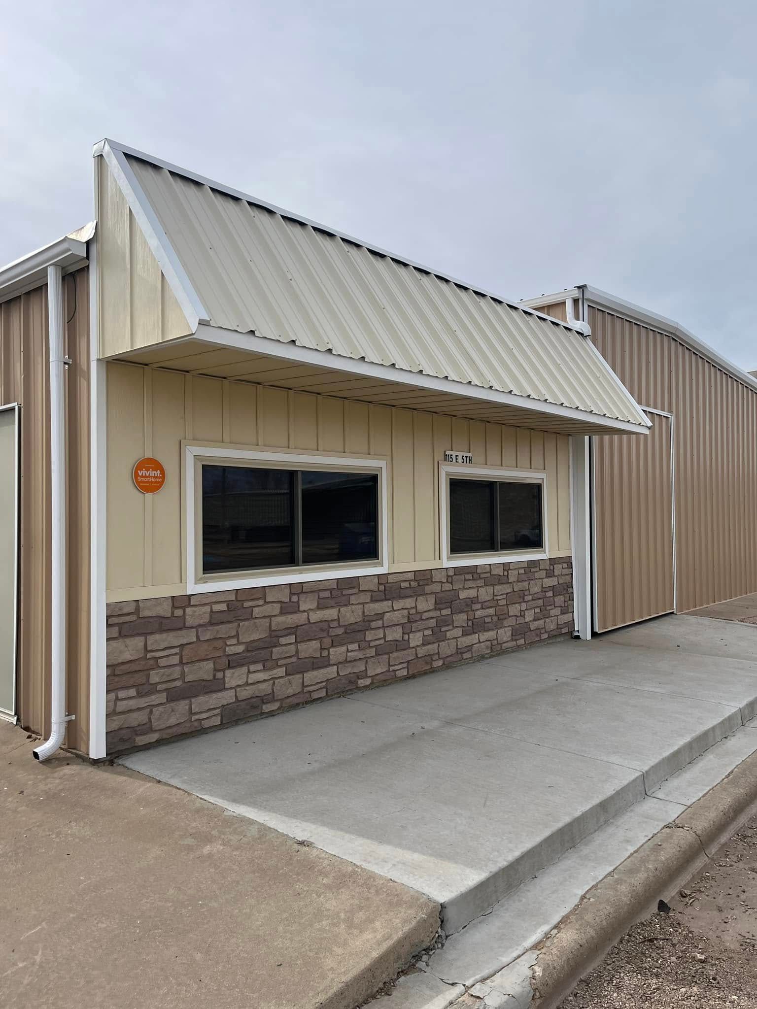A large building with a metal roof and a brick wall.