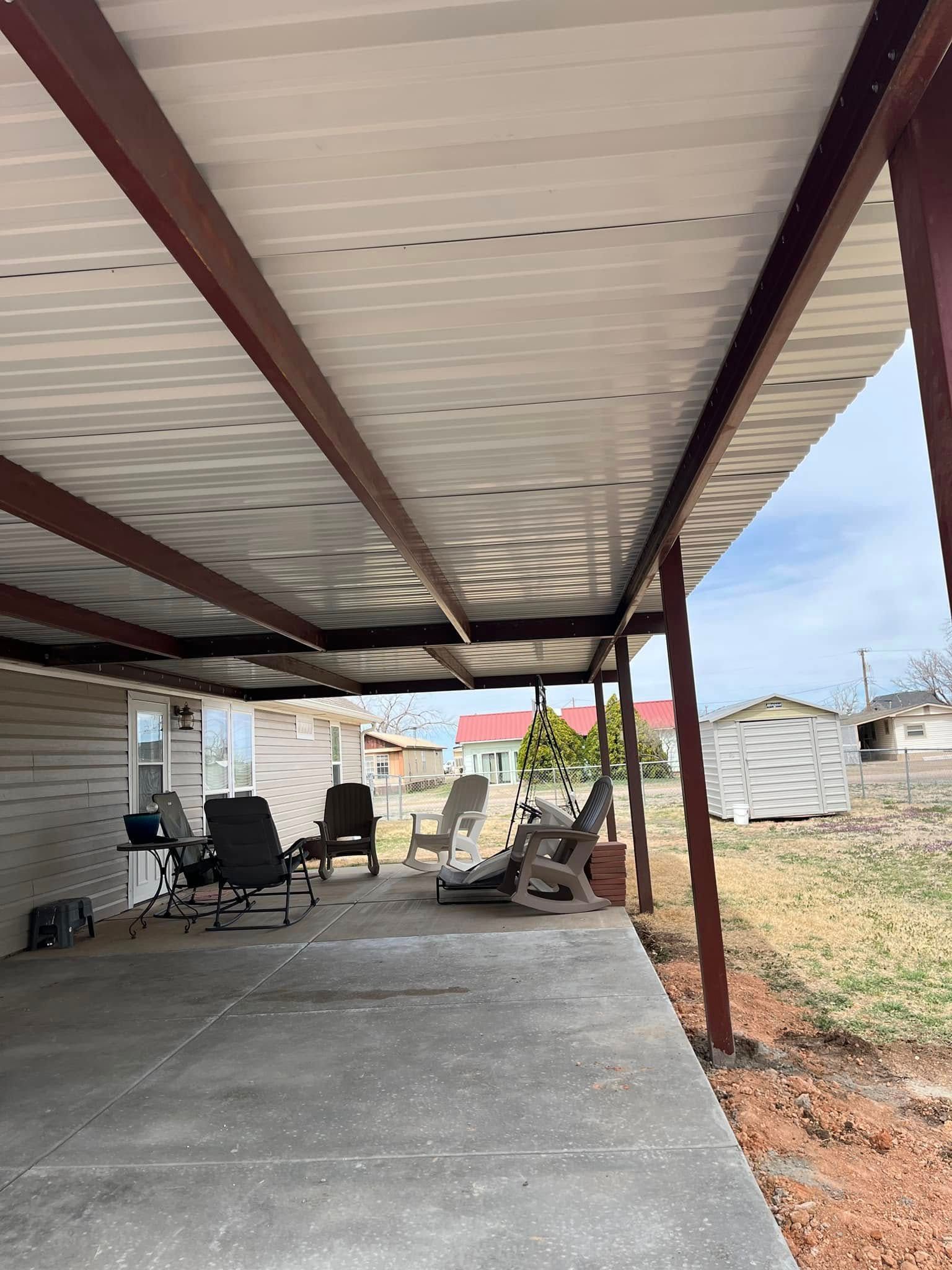 A covered patio with chairs under a roof.