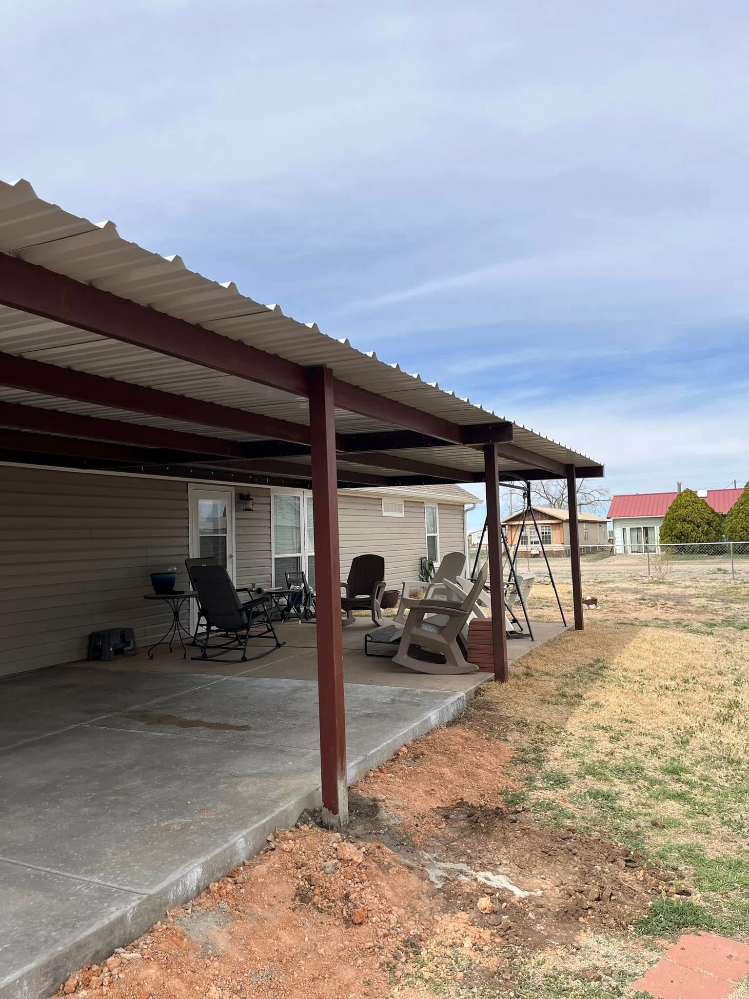A covered patio with chairs and a table under a metal roof.