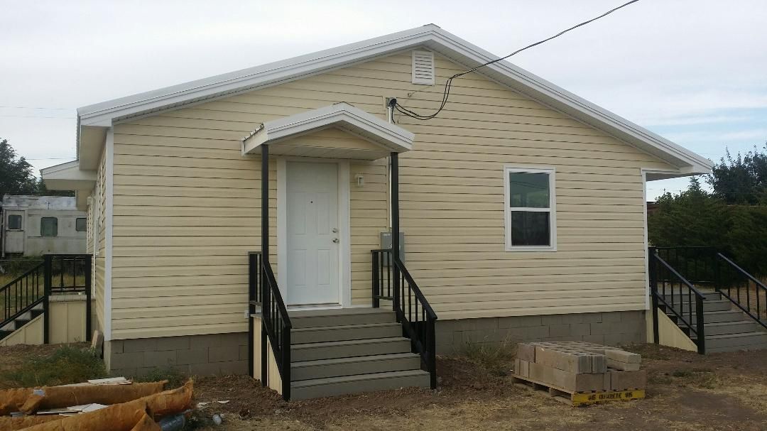A small house with stairs leading up to the front door