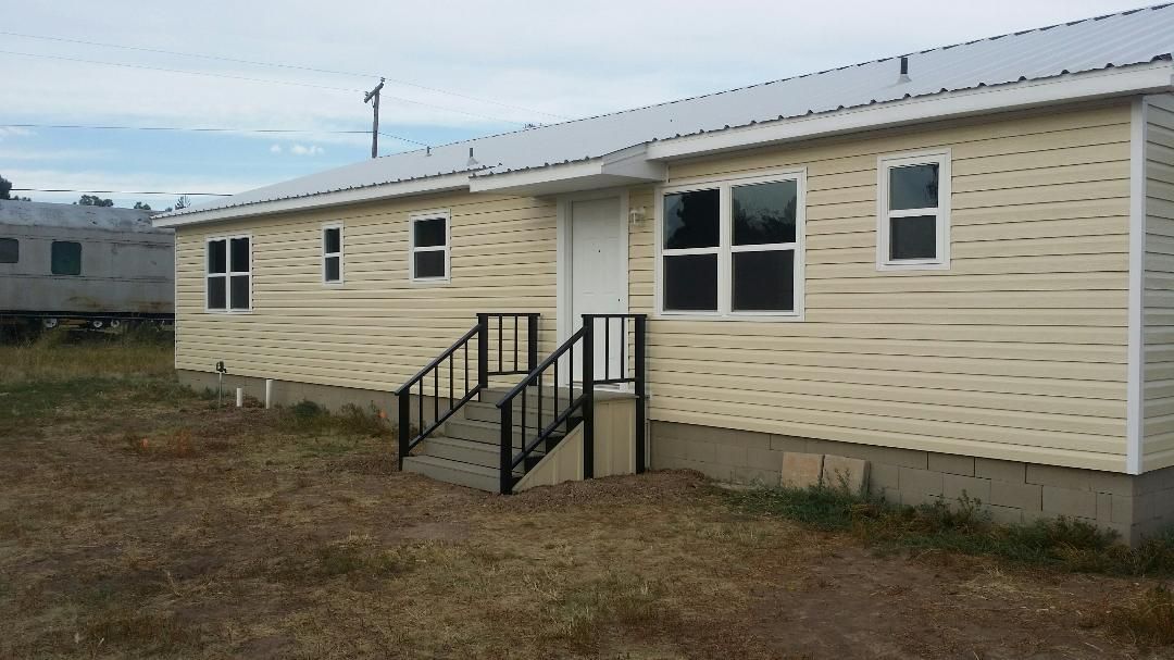 A small house with stairs leading up to the front door