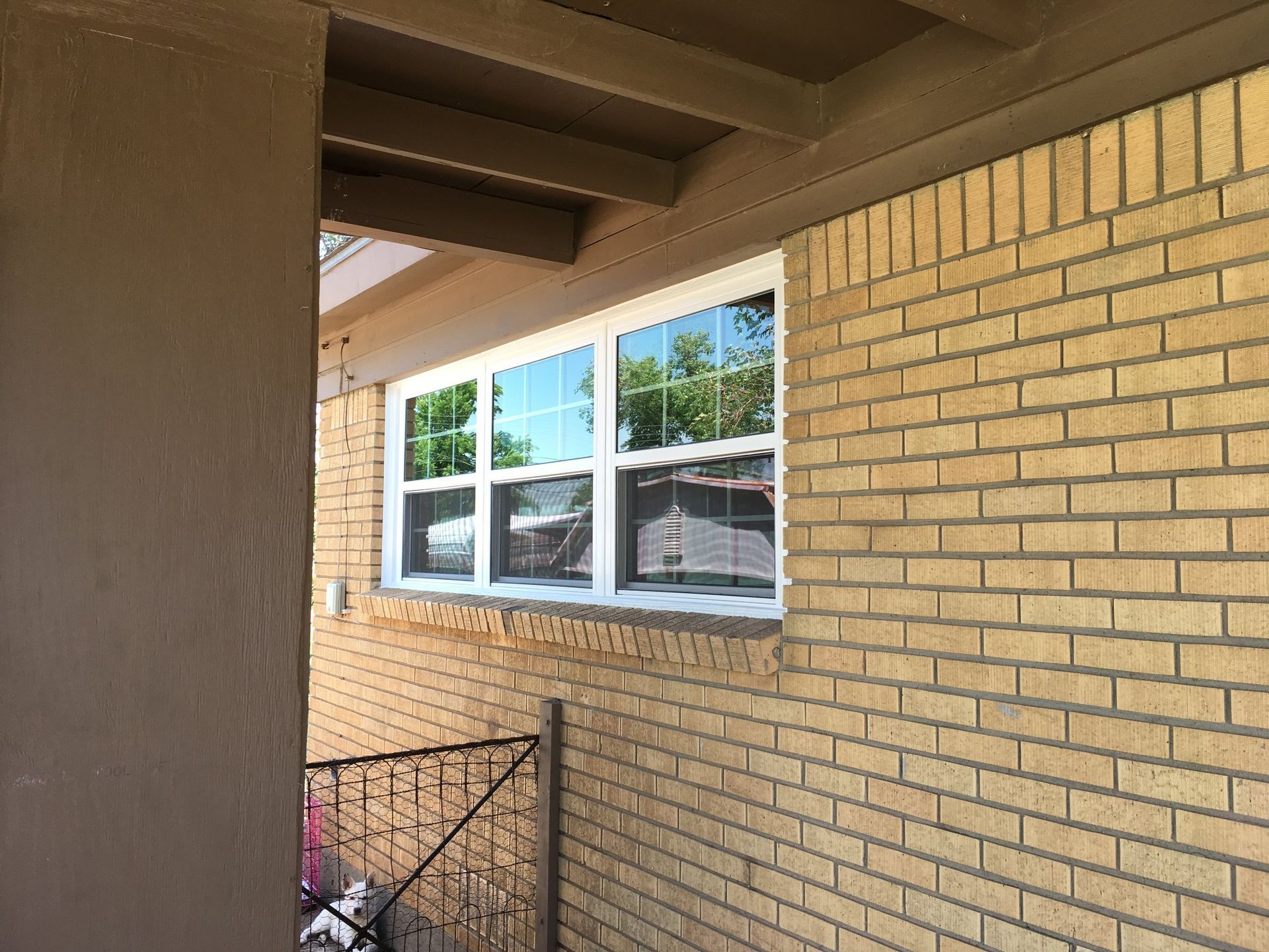 A brick building with a white window on the side of it.