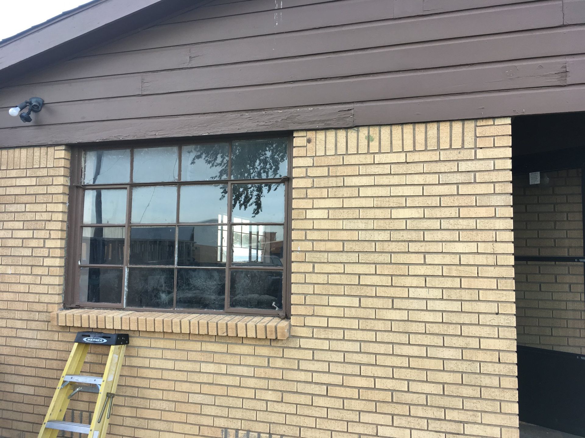 A ladder is sitting on the side of a brick house