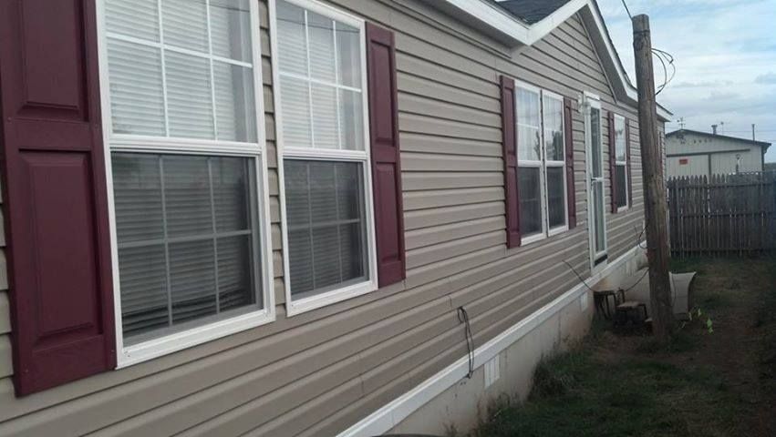 A mobile home with a lot of windows and red shutters.