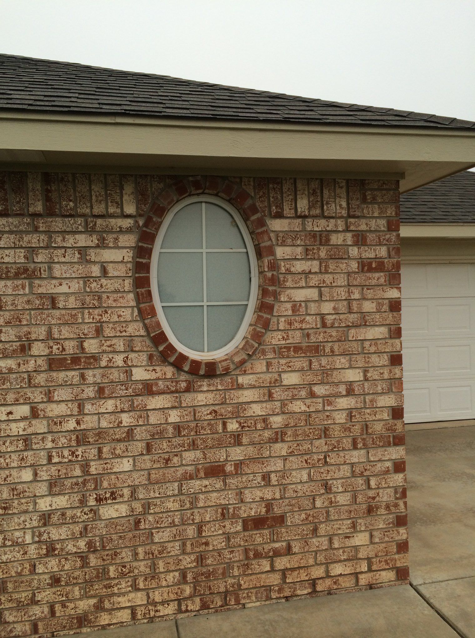 A brick building with an oval window on the side
