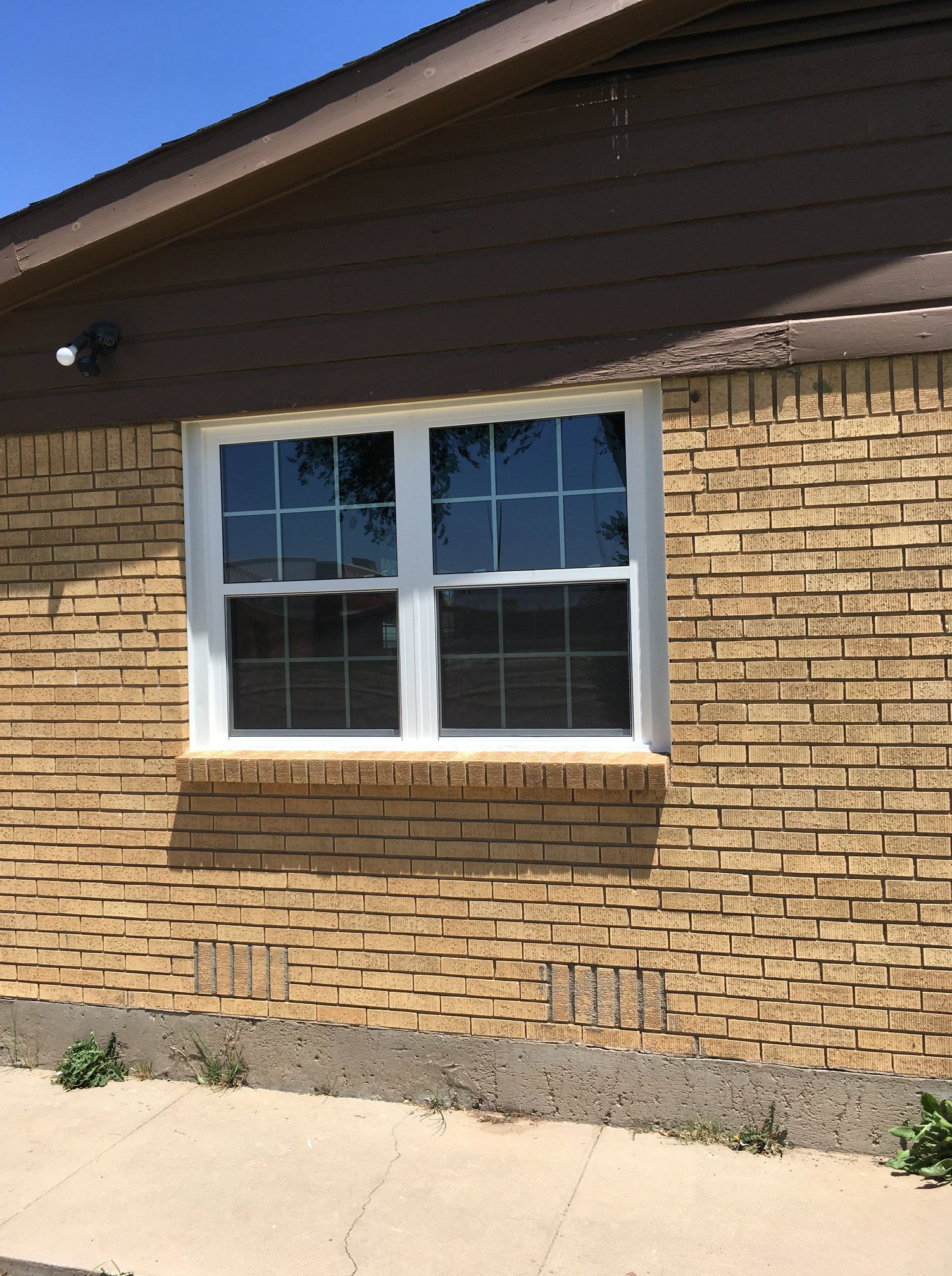 A brick house with a white window on the side