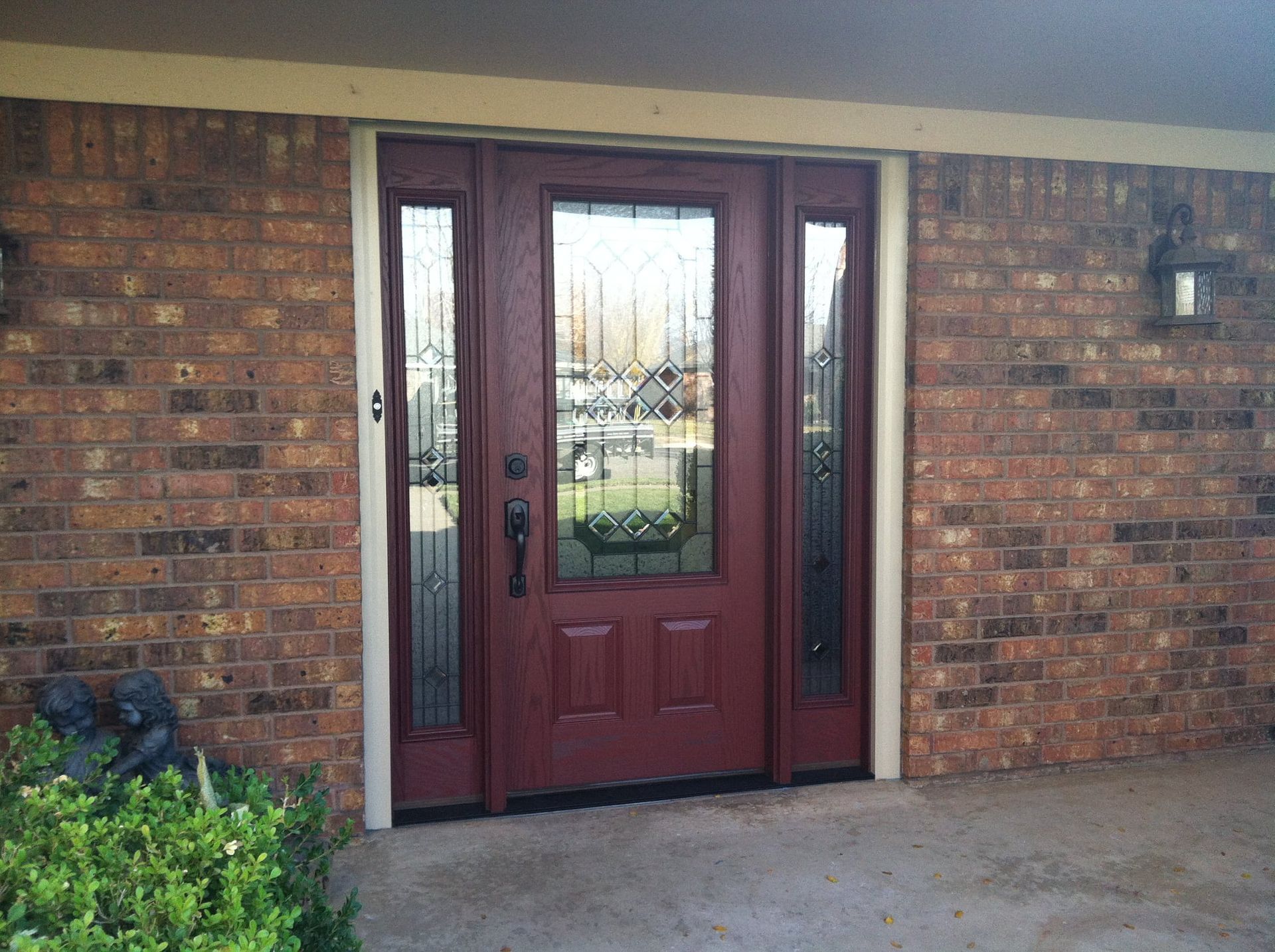 The front door of a brick house with a red door