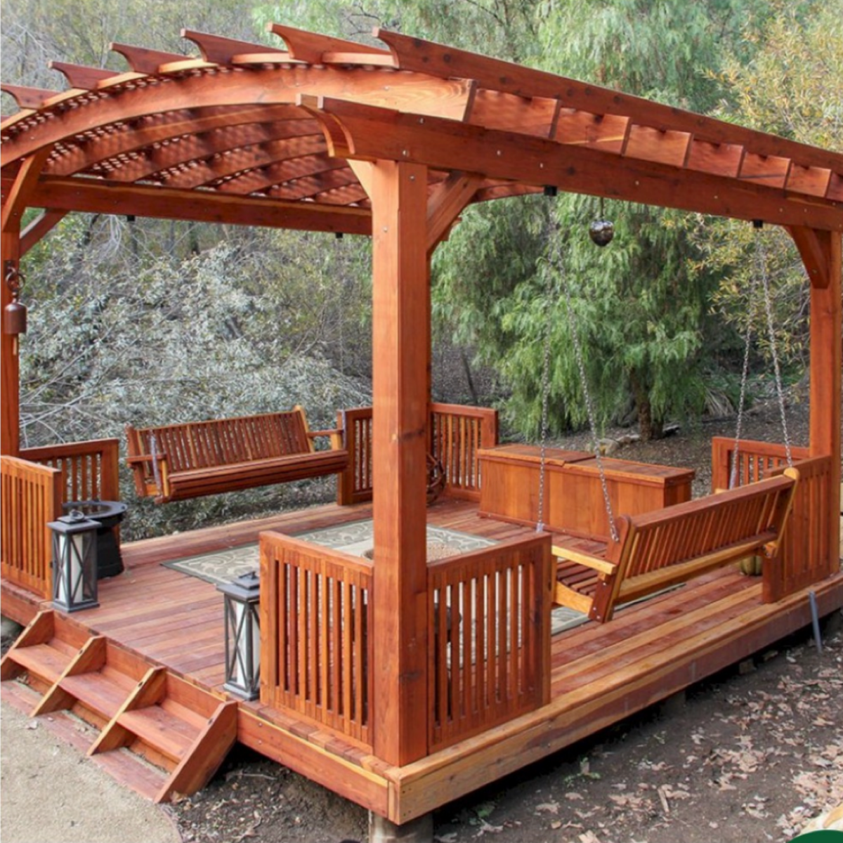 A wooden gazebo with a swing and lanterns
