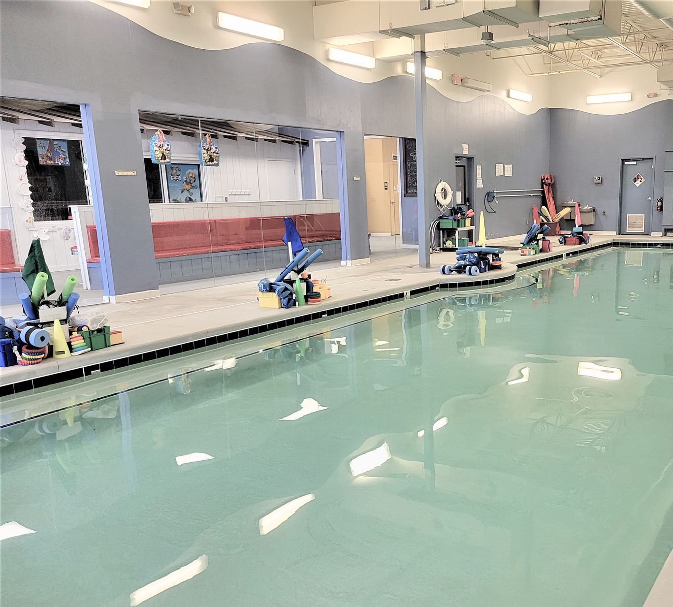 A large indoor swimming pool with a lot of equipment in it.