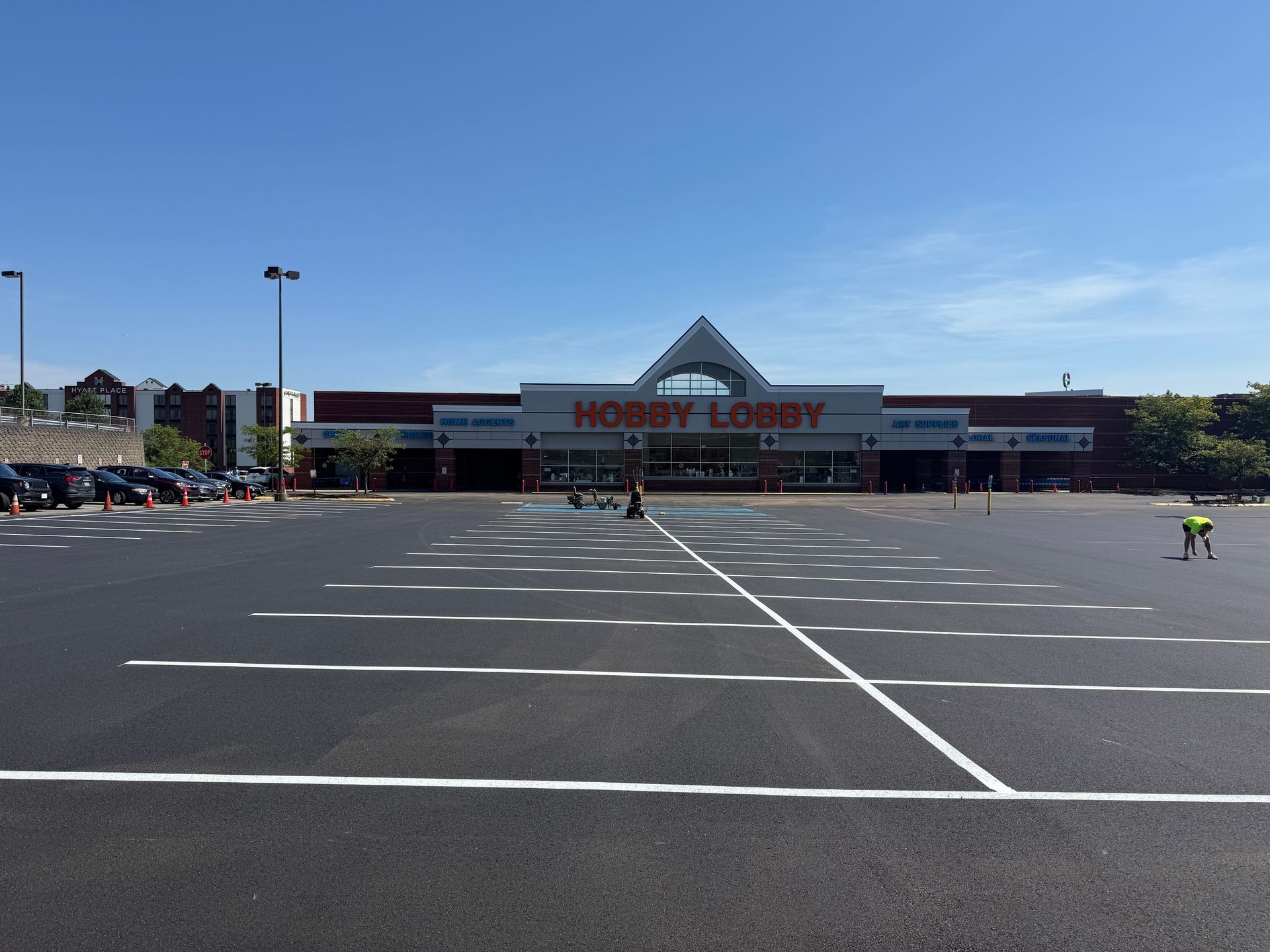 Home Depot storefront with a mostly empty parking lot under a clear blue sky