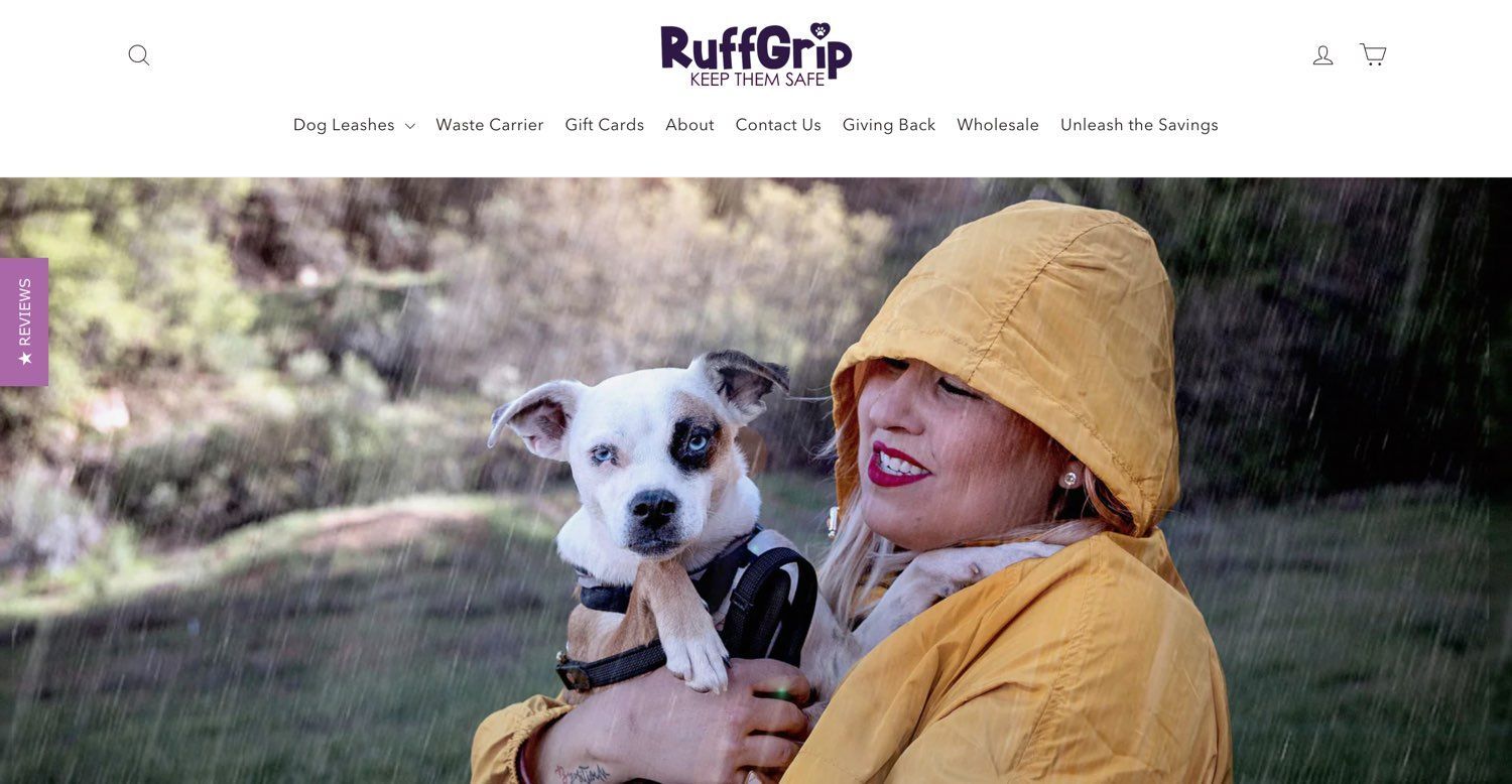 A woman in a yellow jacket is holding a small dog with a Ruff Grip leash.