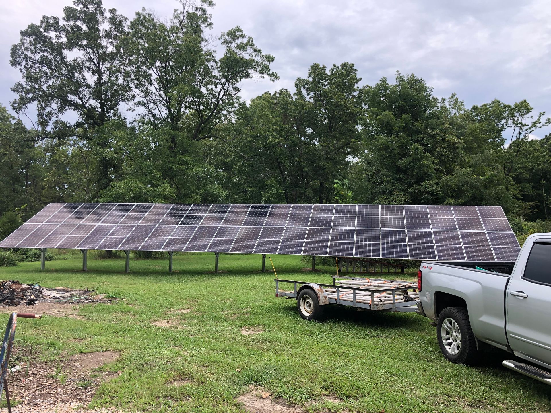 A truck is towing a trailer with solar panels on it.