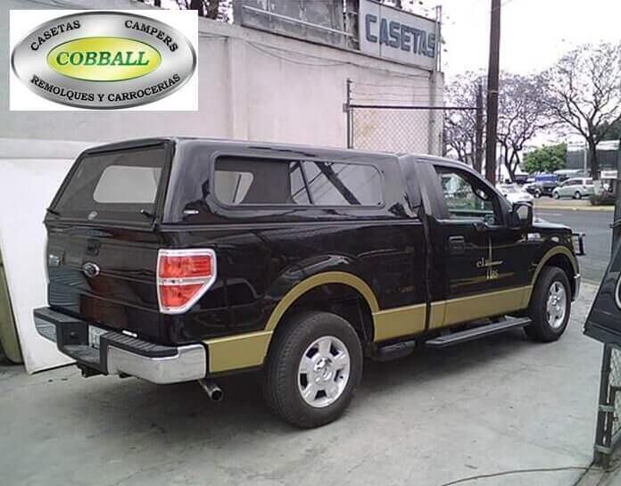 Una camioneta Ford negra con una cubierta para la caja a juego y detalles en color beige estaba estacionada frente a la tienda Cobball.