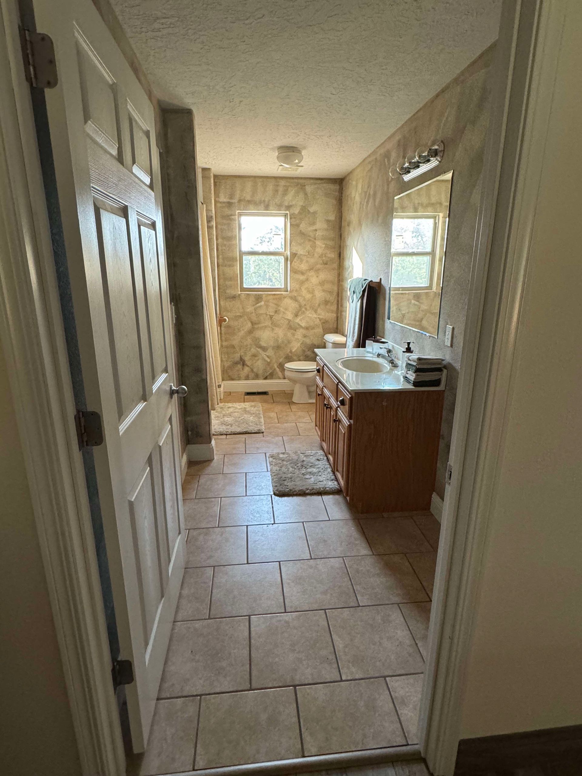 A bathroom with a sink , toilet and mirror.
