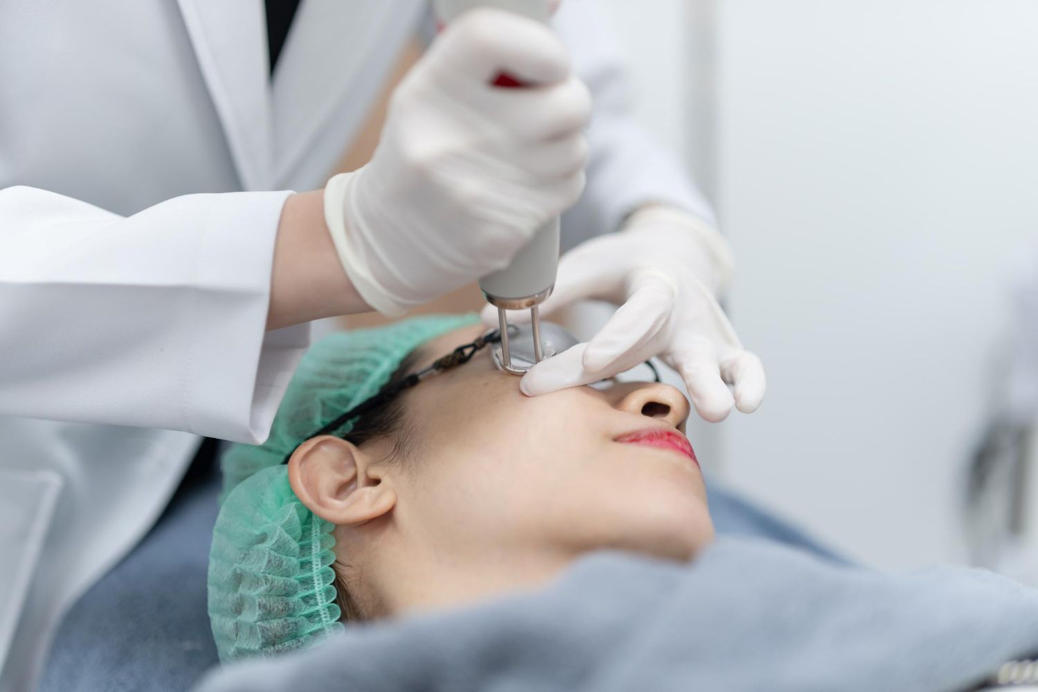 A woman is getting a laser treatment on her face.