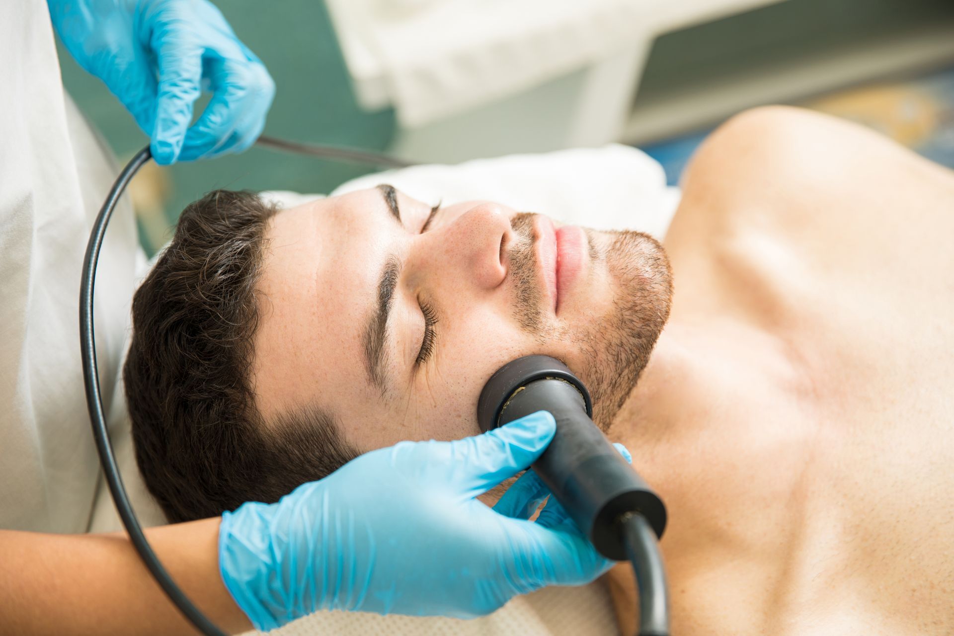 A man is getting a facial treatment at a spa.