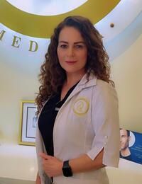 a woman in a white coat is standing in front of a sign .