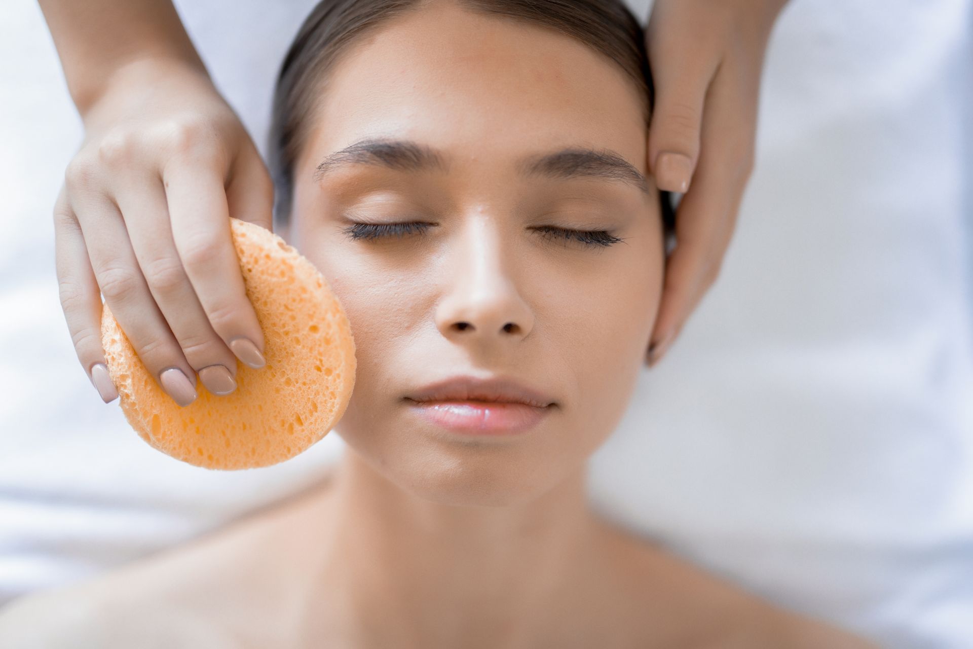 a woman is getting a facial massage with a sponge .