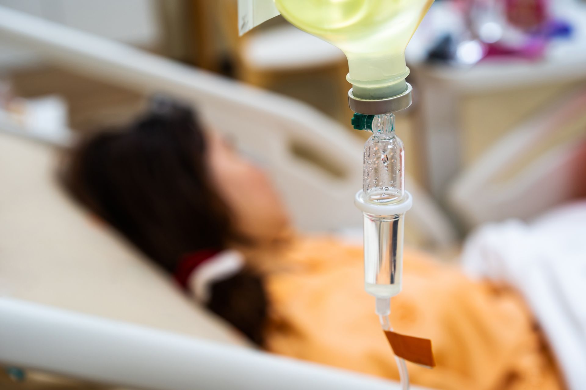 a woman is laying in a hospital bed with an iv in her arm .