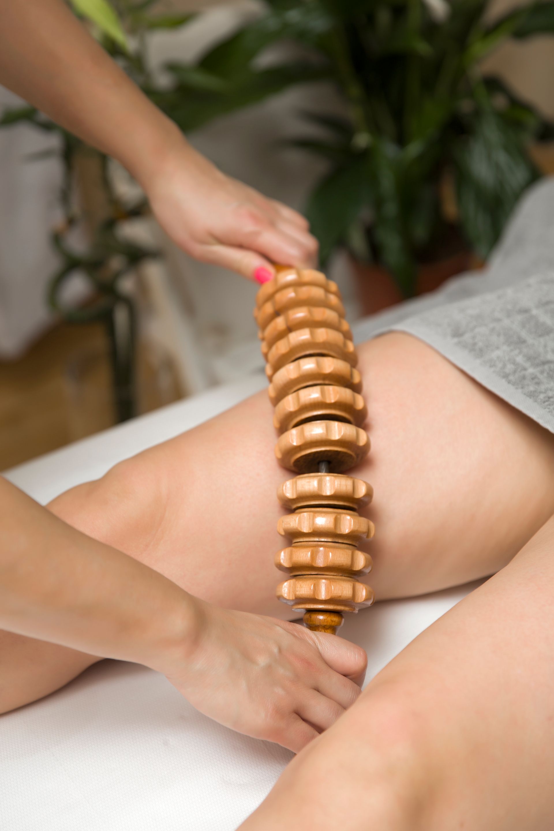 a woman is getting a wooden massage on her leg .