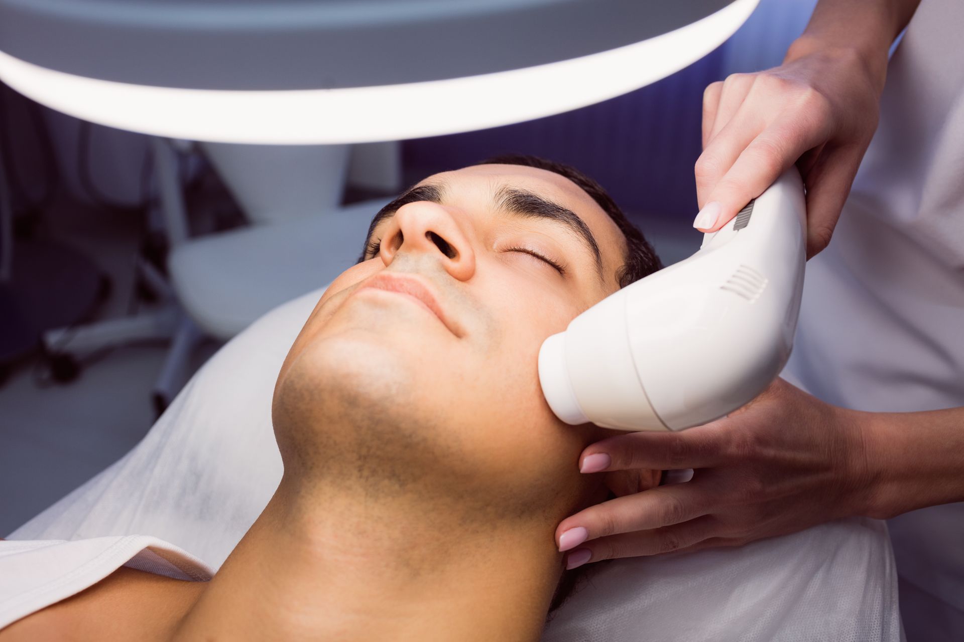 a man is getting a laser treatment on his face .