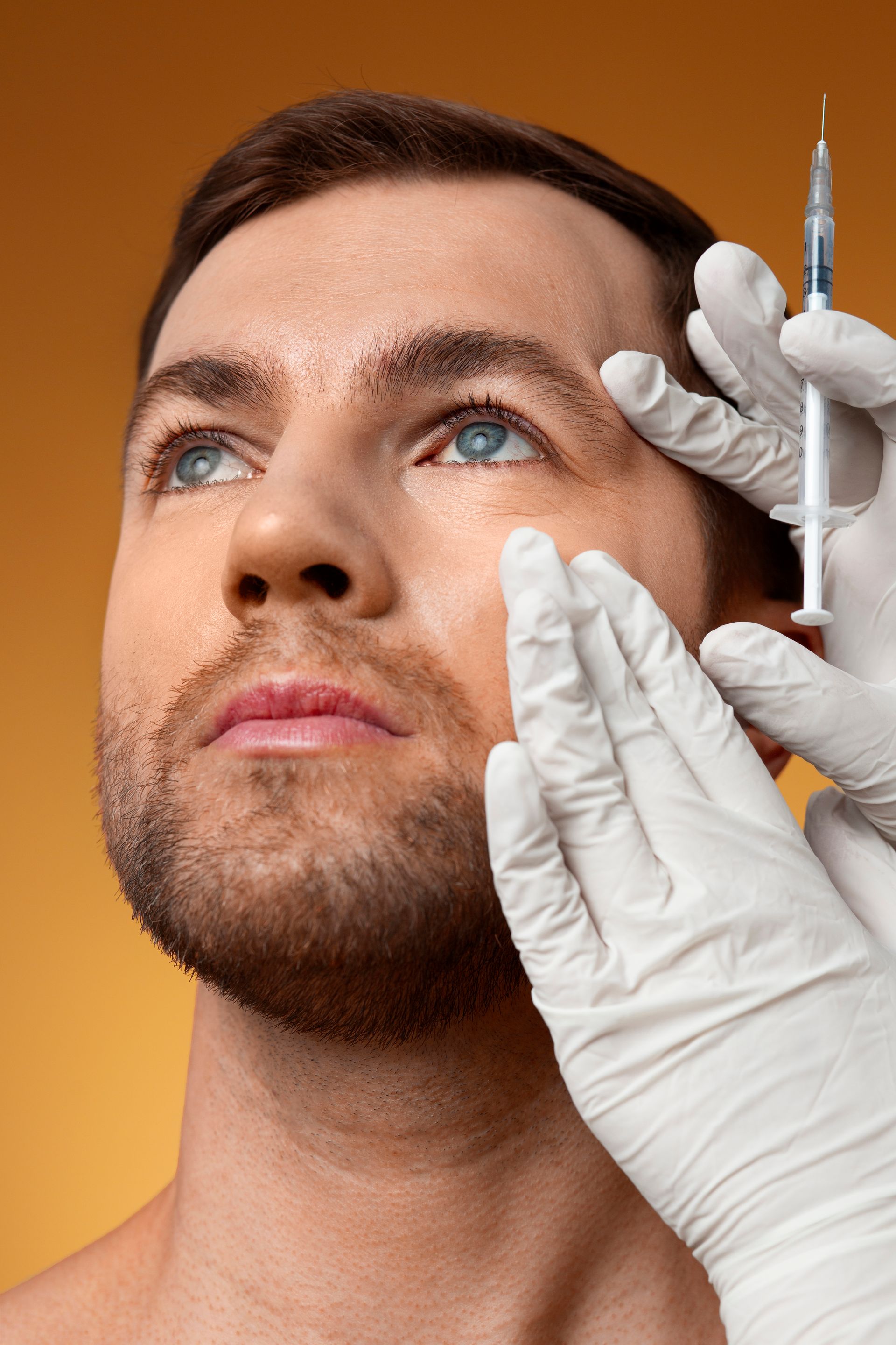 a man is getting a botox injection in his eye .