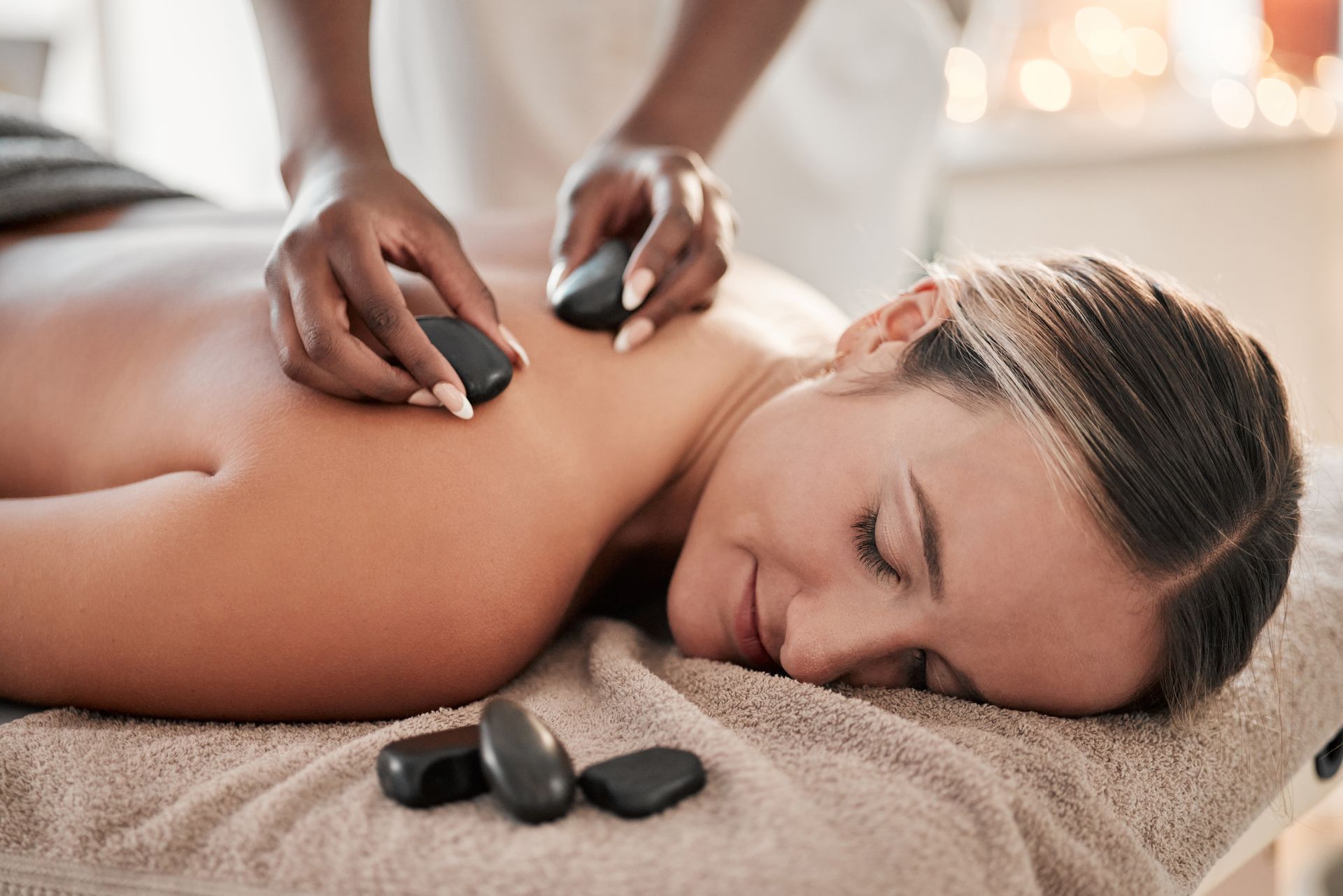 A woman is getting a hot stone massage at a spa.