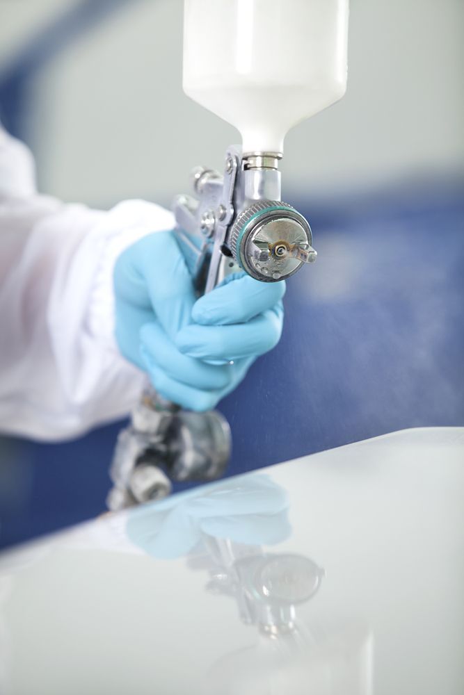 Man With Blue Gloves Holding A Spray Paint — Taminda Smash Repairs In Gunnedah, NSW