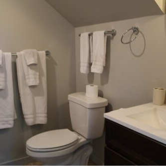 Small bathroom with a toilet, towels, and a sink.