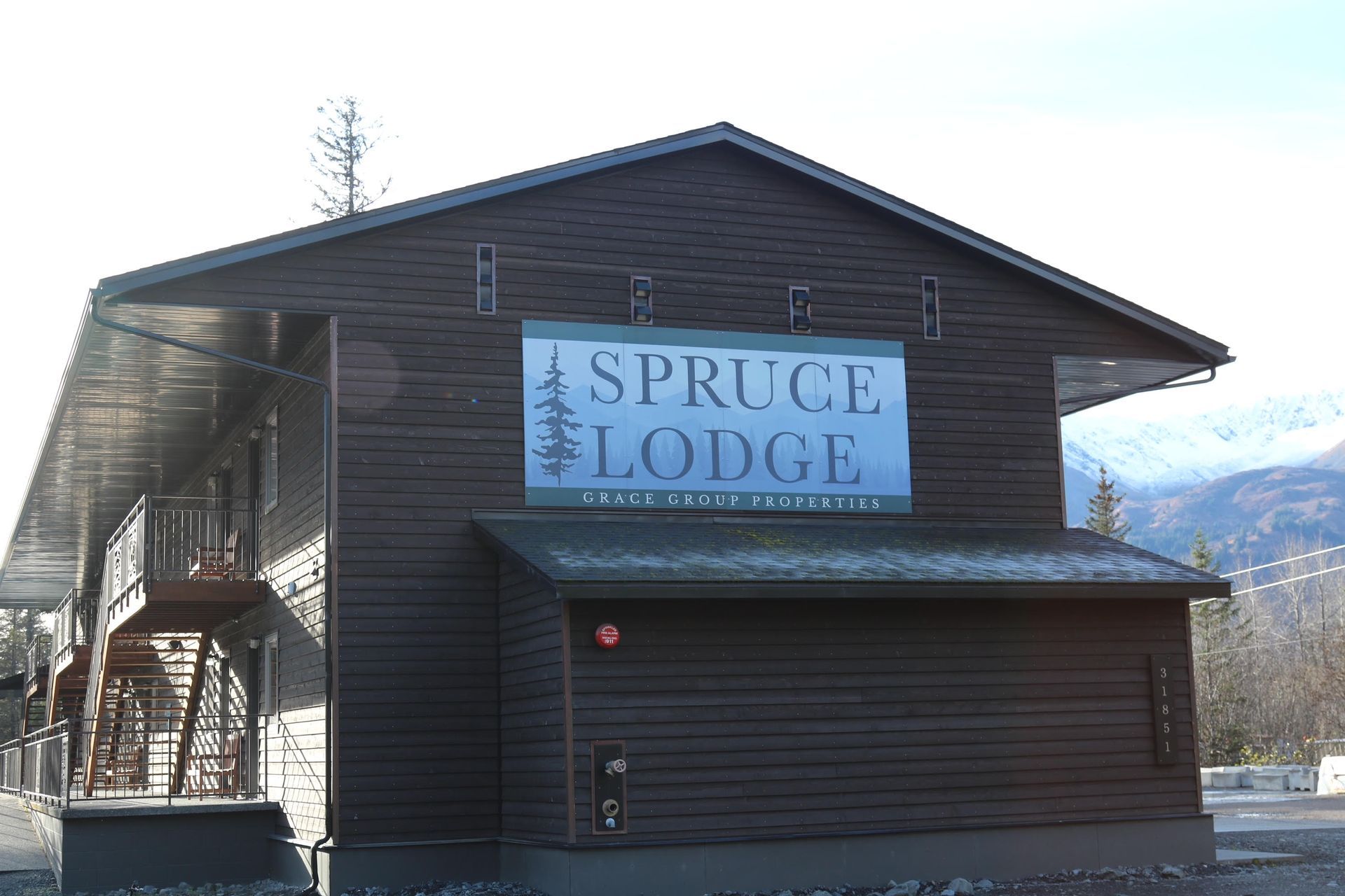 Brown Spruce Lodge building with a sign.