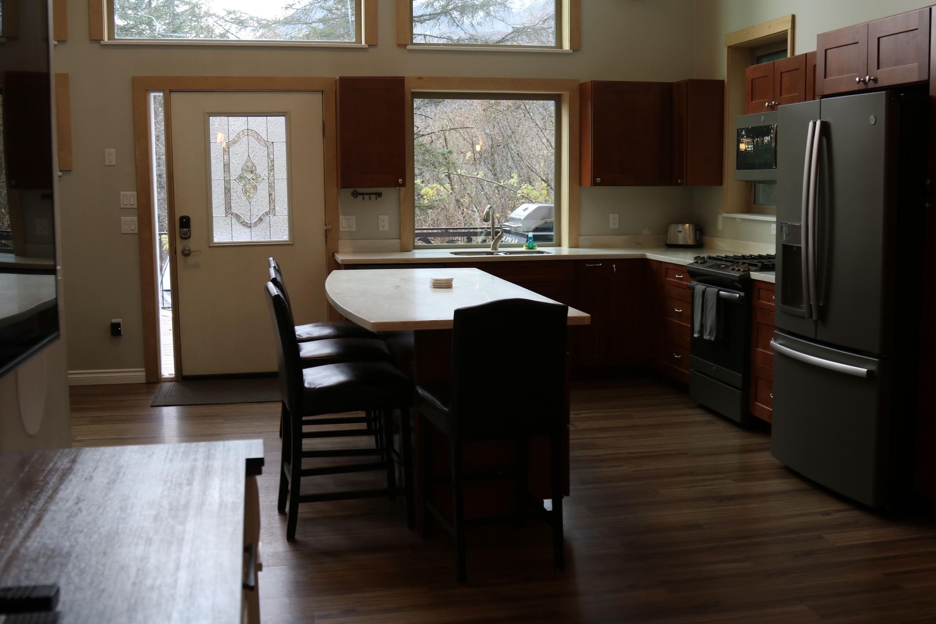 Kitchen with dark cabinets, stainless steel appliances, breakfast bar, and an exterior door.