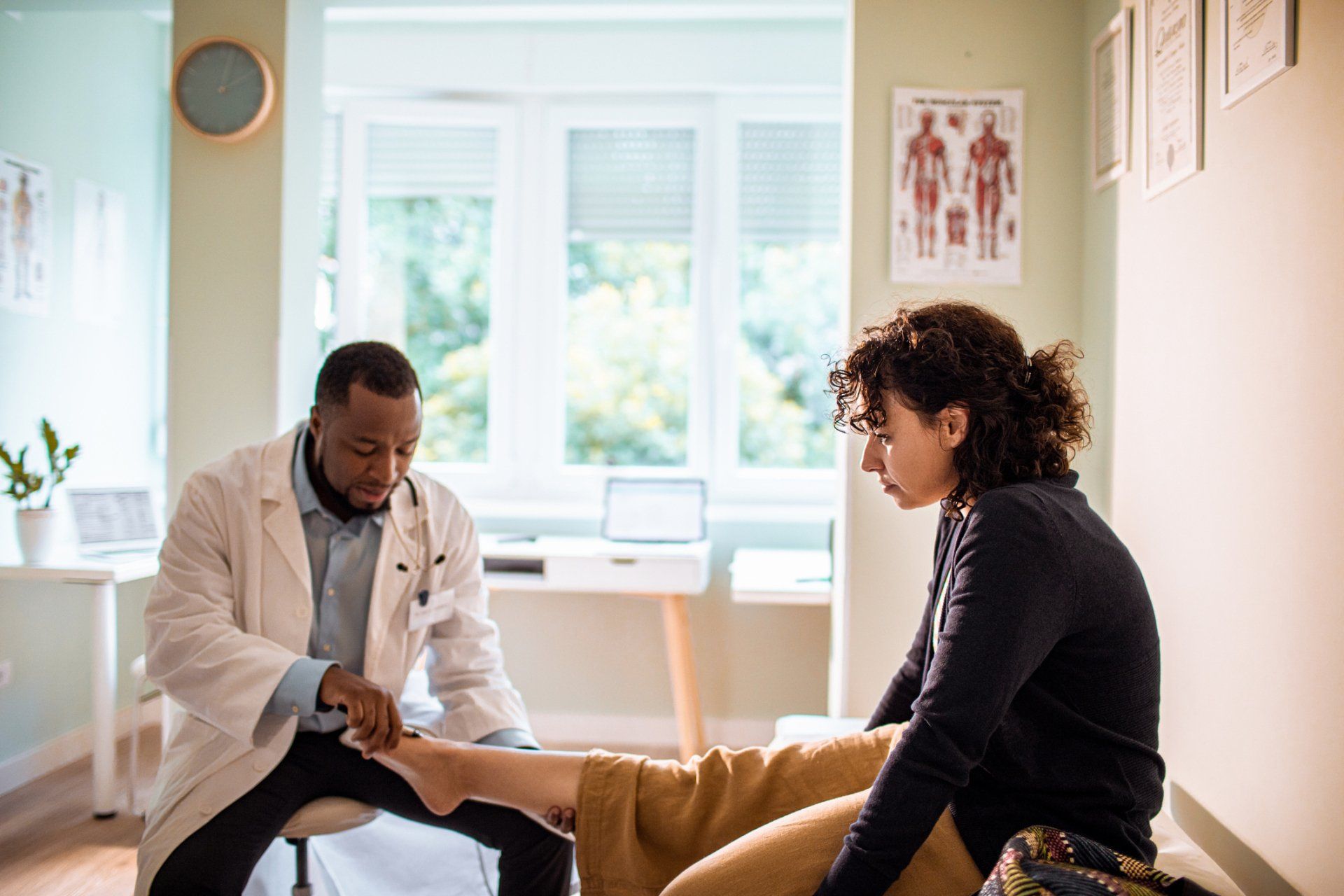 Doctor examining a patient's foot in a medical office.