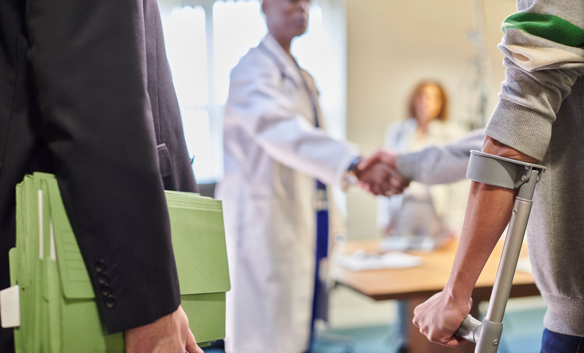 A man with crutches shaking hands at an accident injury clinic, symbolizing support and recovery. A man with crutches shaking hands at an accident injury clinic, symbolizing support and recovery.
