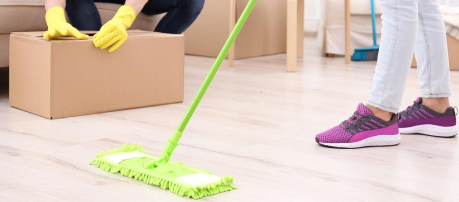 A woman is cleaning the floor with a mop in a living room.