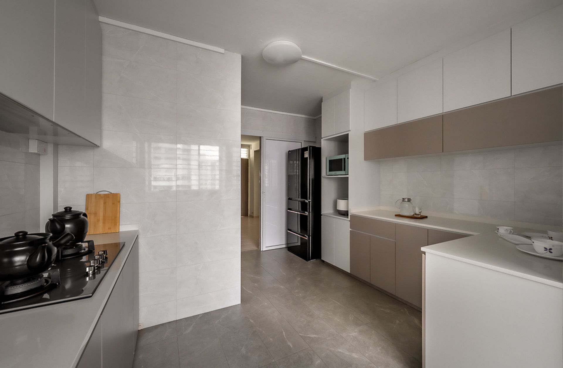 A kitchen with white cabinets and a black refrigerator.