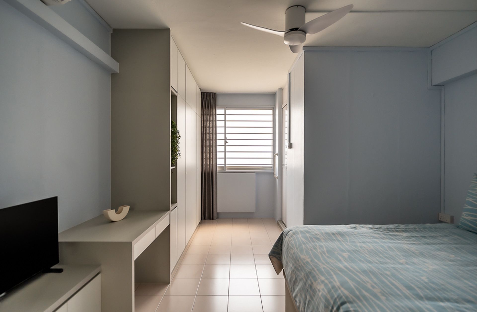 A bedroom with a ceiling fan and a bed