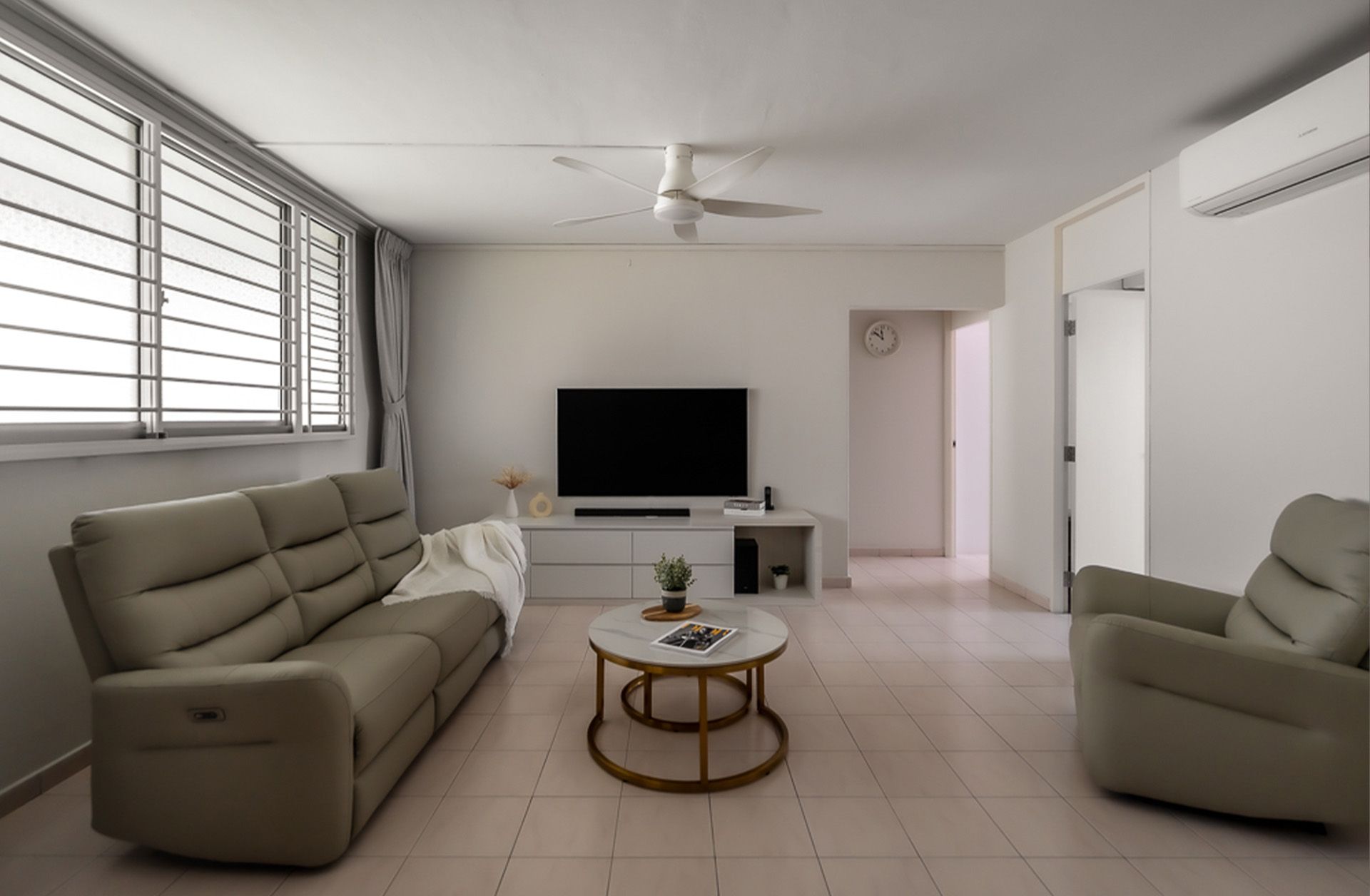 A living room with a couch , chair , coffee table and television.