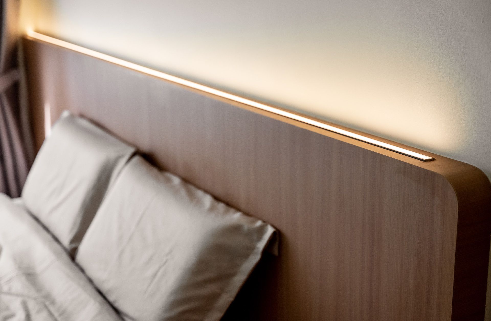 A bed with a wooden headboard and white pillows