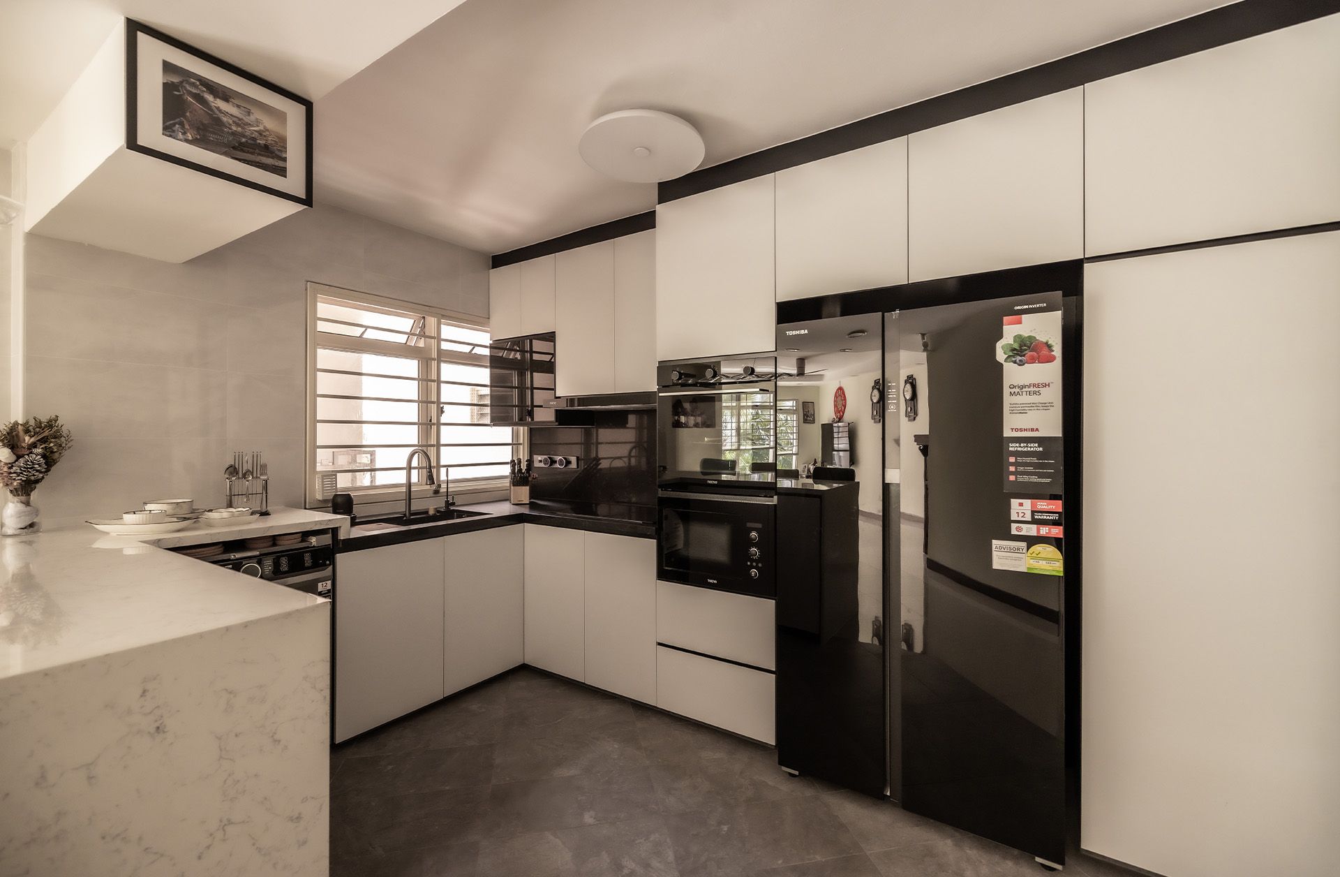 A kitchen with white cabinets and a black refrigerator.