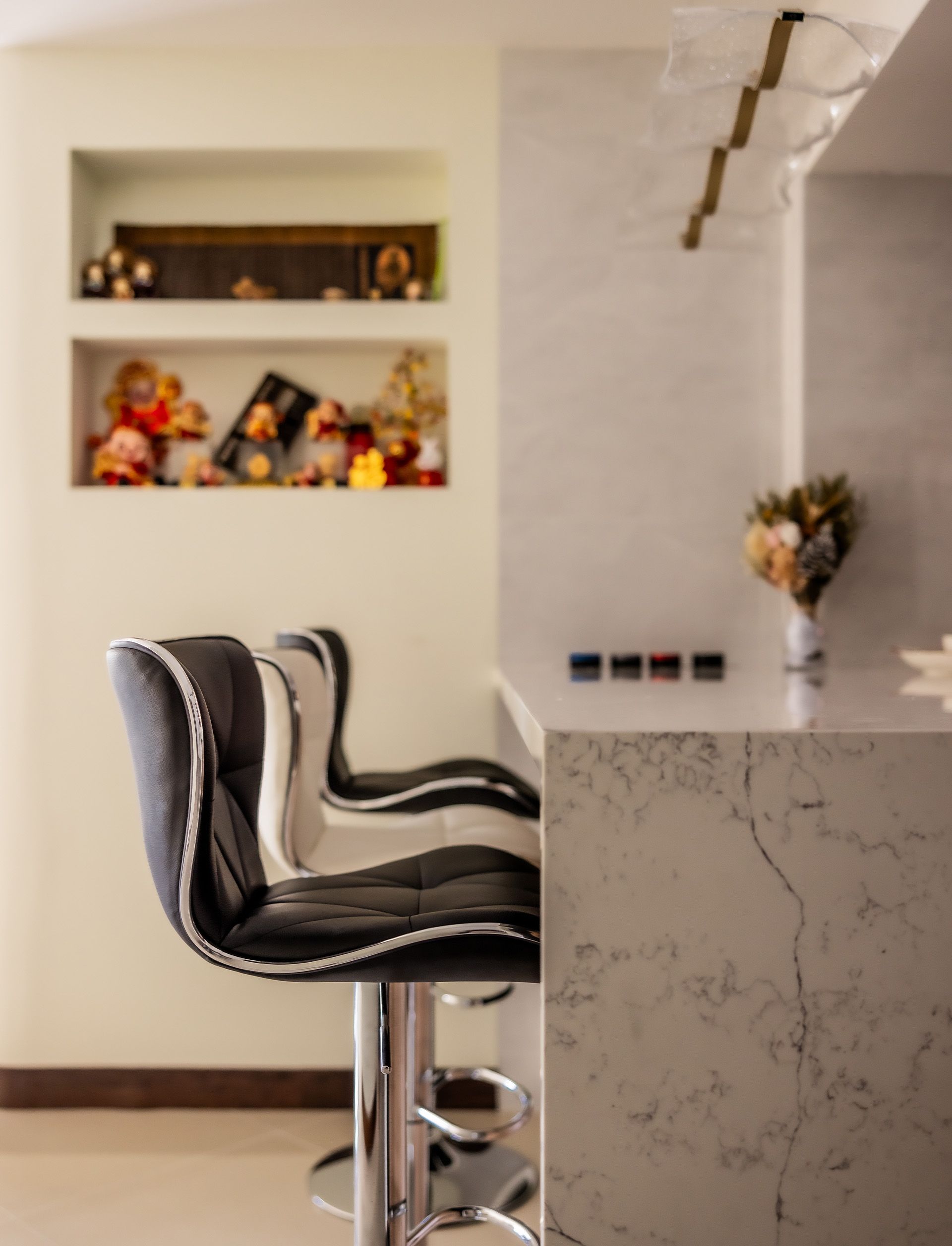 Two bar stools are sitting next to a counter in a kitchen