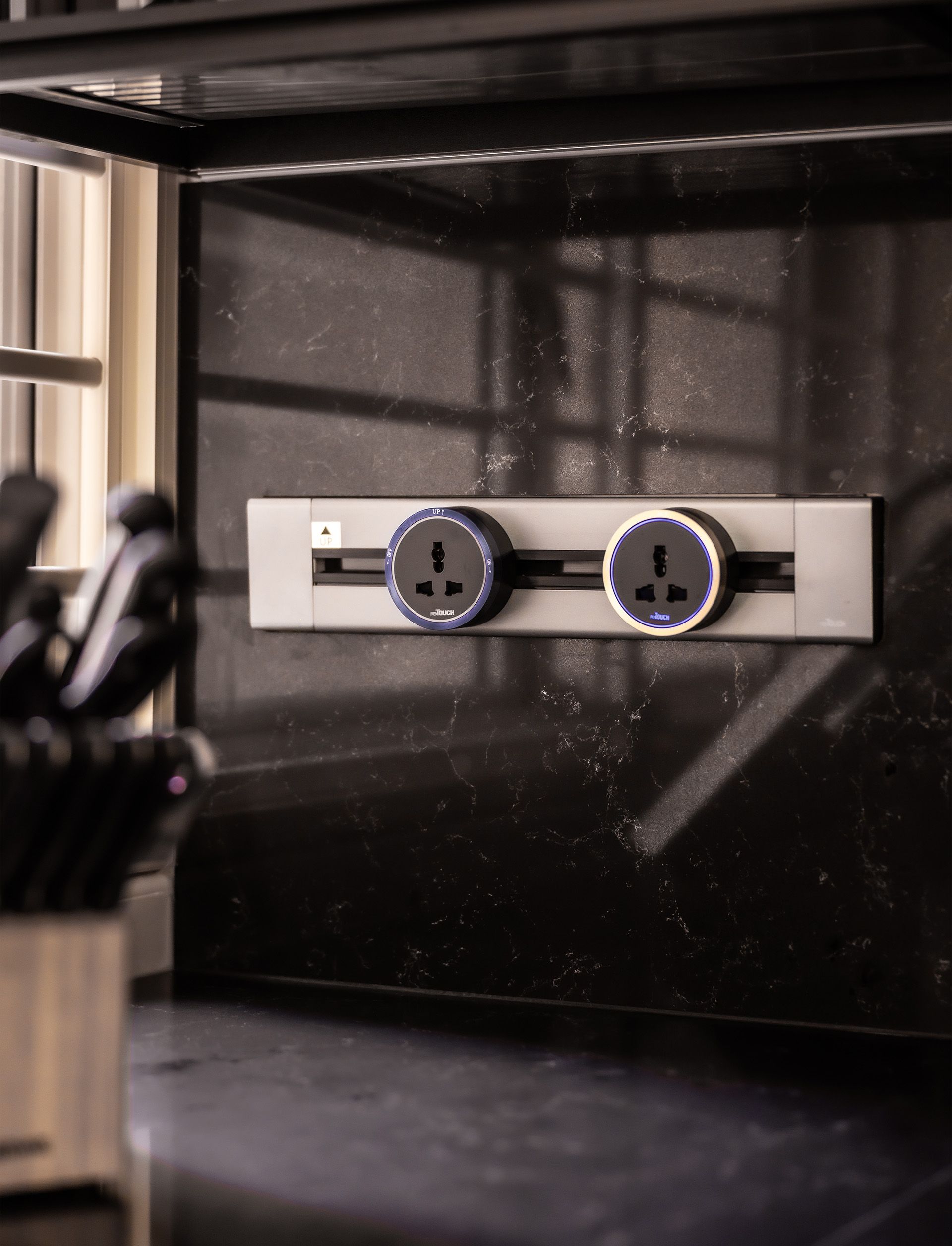 A black wall with two electrical outlets on it