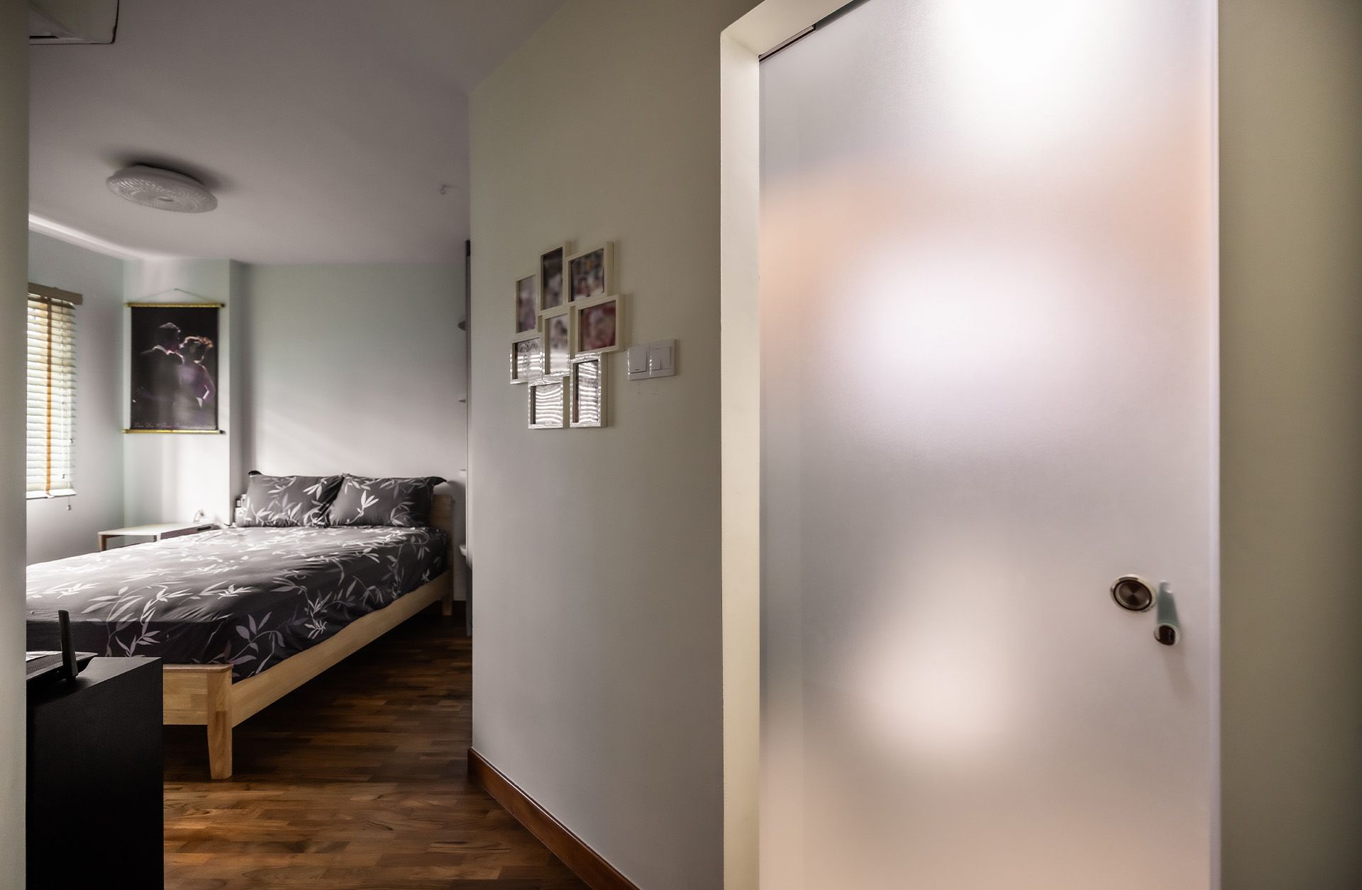 A bedroom with a bed and a glass door leading to it.