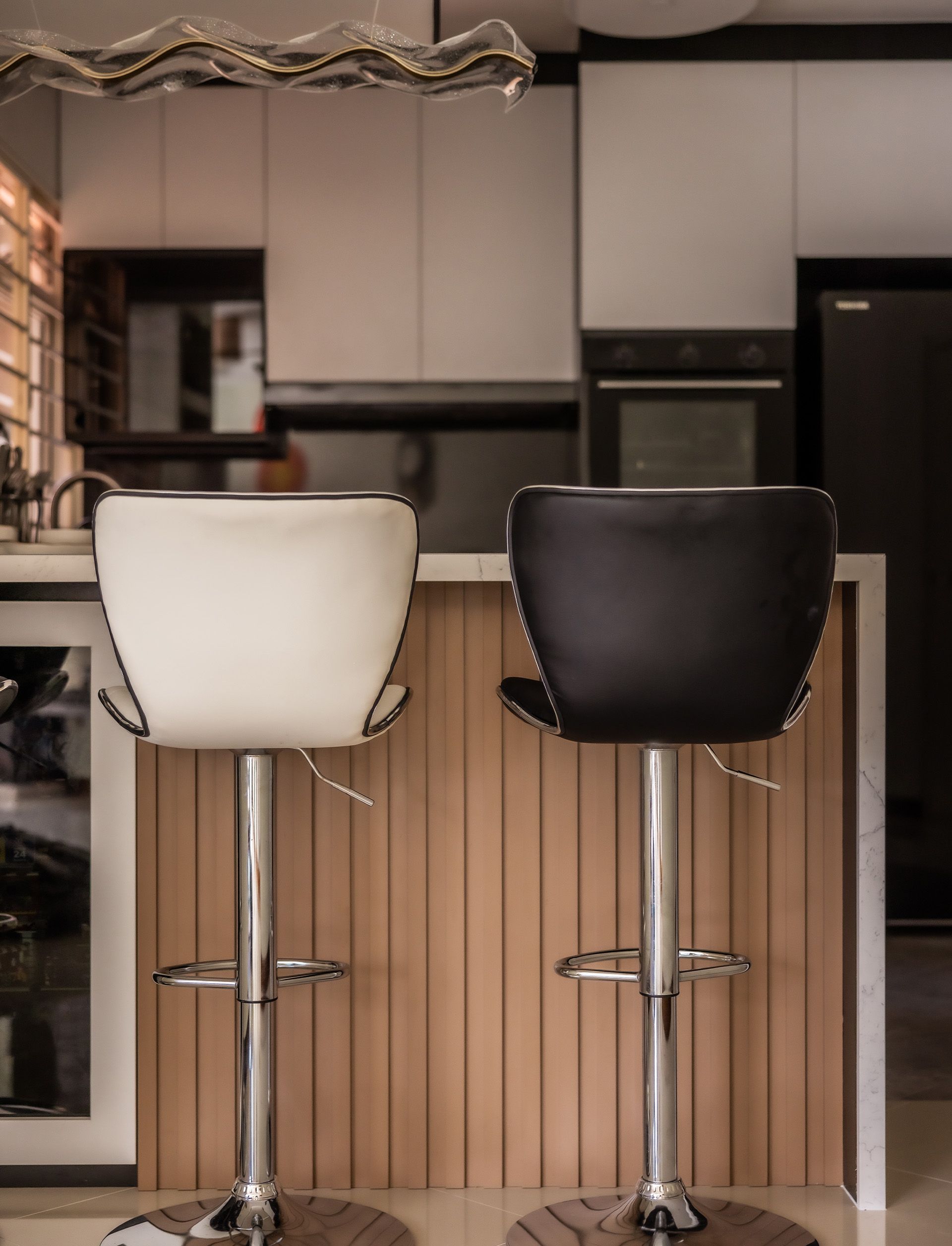 Two bar stools are sitting next to each other in a kitchen.