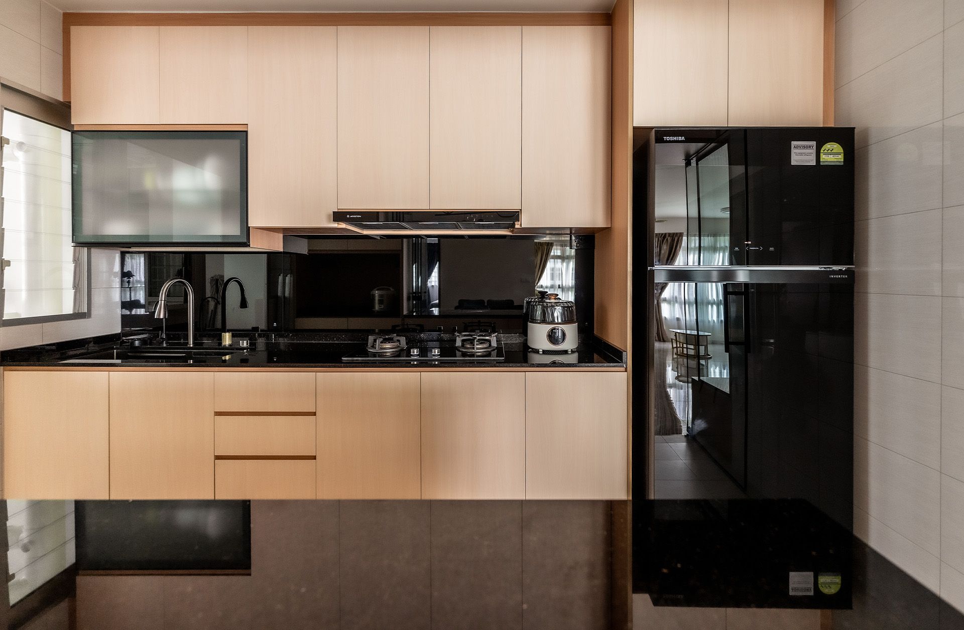 A kitchen with wooden cabinets and a black refrigerator.