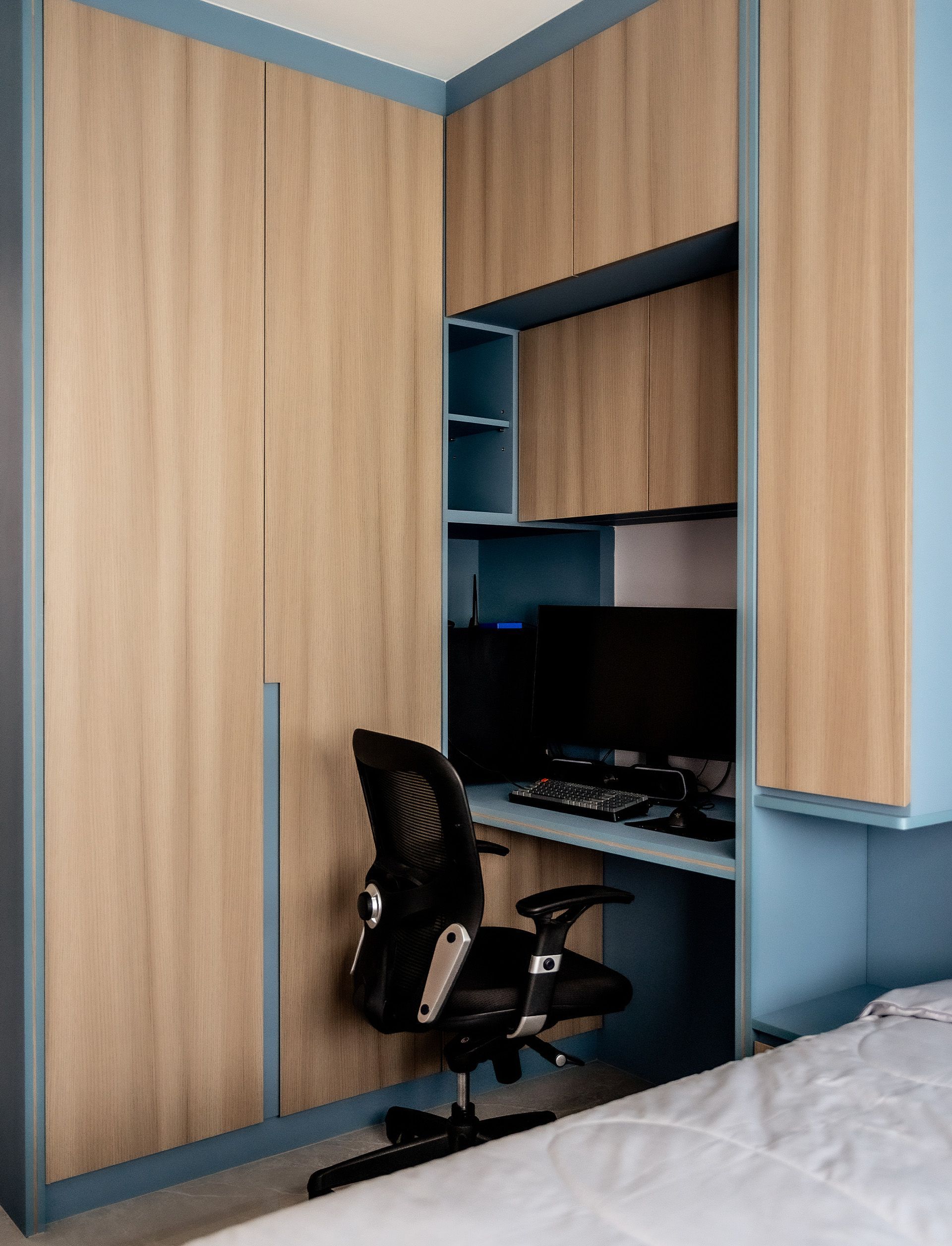 A bedroom with a desk and chair and a computer on it.