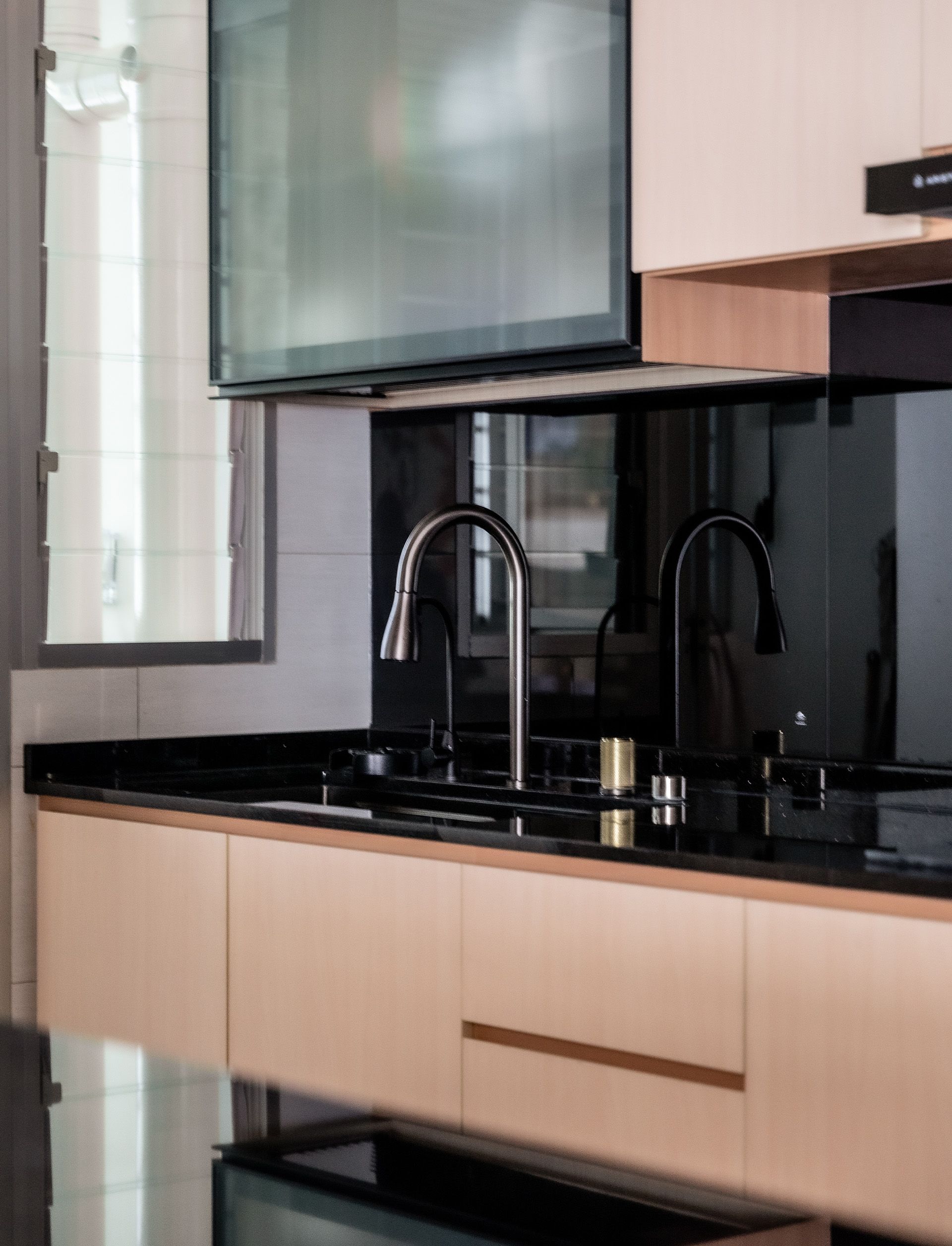 A kitchen with a sink and a television above it