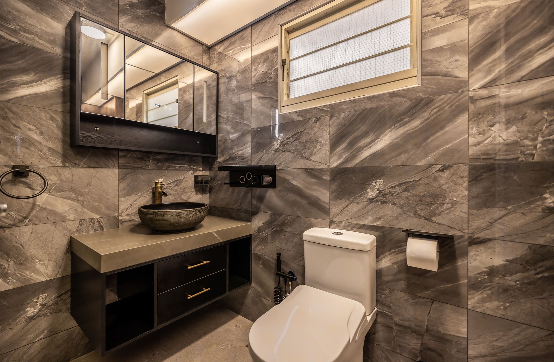 A bathroom with a toilet , sink , mirror and window.