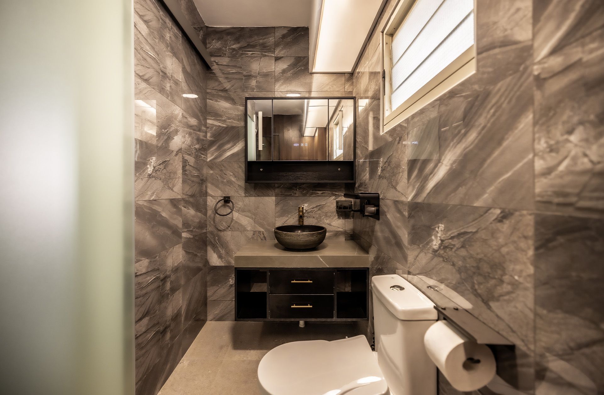 A bathroom with a toilet , sink and mirror.