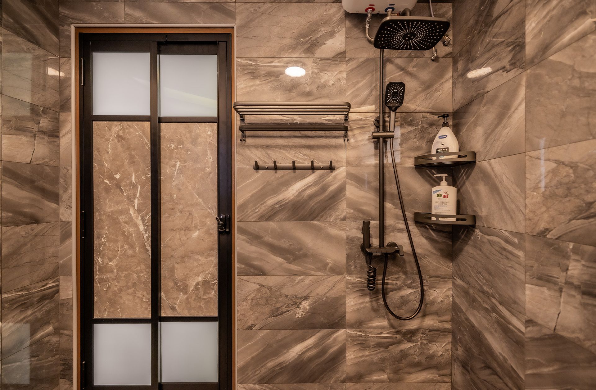 A bathroom with a sliding glass door and a shower head.