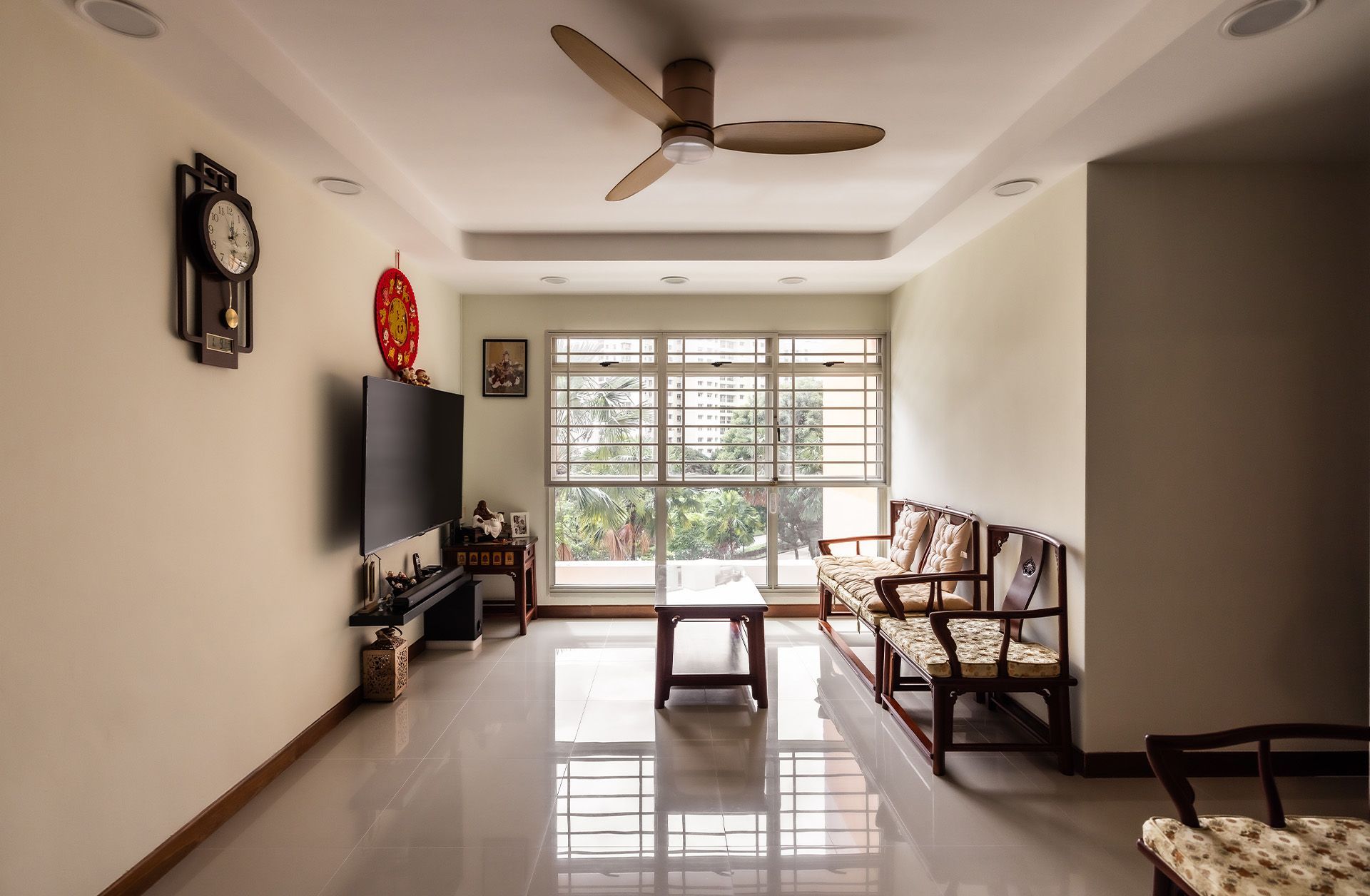 A living room with a ceiling fan and a clock on the wall